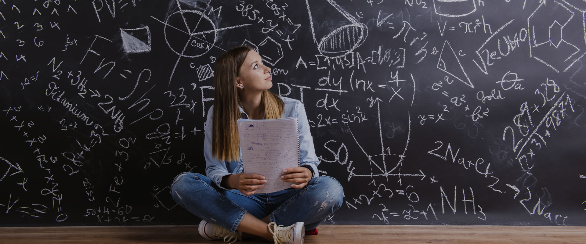 A woman staring at the wrintings on the black board